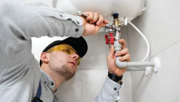 Technician repairing a wall-mounted water heater in a Dubai residential bathroom
